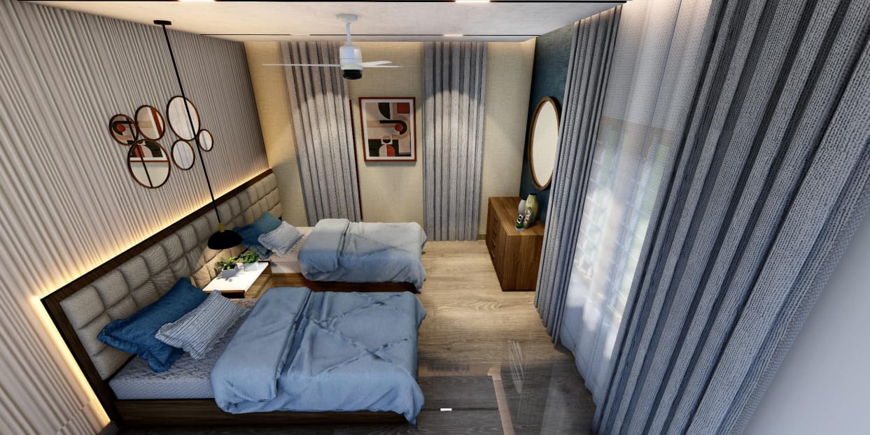 Twin beds seen from above with layered blue quilts and sheer curtains